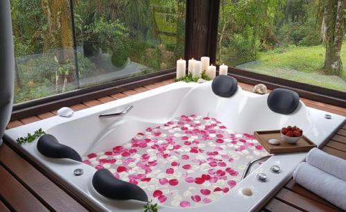 a bath tub filled with flowers in a room with a window at Refúgio Bocaina in Bocaina do Sul