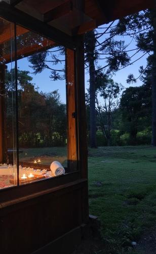 a window of a house with a view of a field at Refúgio Bocaina in Bocaina do Sul