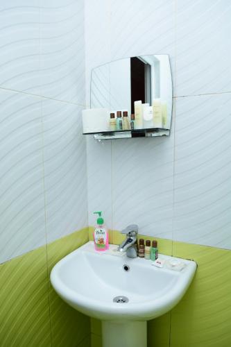a white sink in a bathroom with a mirror at Hotel Kvareli in Tbilisi City