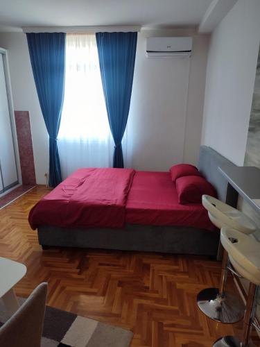 sypialnia z czerwonym łóżkiem i oknem w obiekcie Park apartment w mieście Brczko