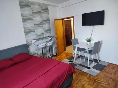 sypialnia z łóżkiem, stołem i telewizorem w obiekcie Park apartment w mieście Brczko