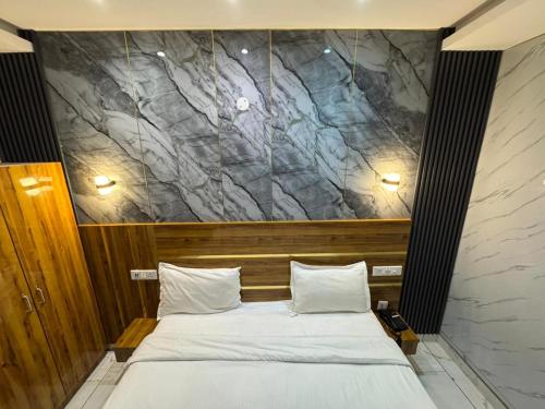 a bedroom with a bed with a stone wall behind it at Nurem Hotel and Resort in Lalru
