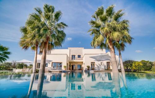 a house with palm trees in front of a swimming pool at Son Sard Nou in Son Servera