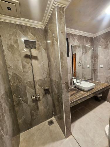 a bathroom with a shower and a sink at Ambassador Suites in Dargai
