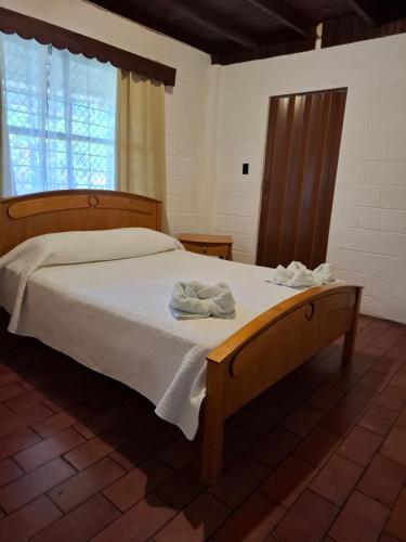 a bedroom with a bed with two towels on it at Coco Beach House in Coco