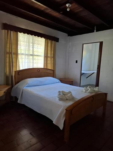 a bedroom with a bed with two towels on it at Coco Beach House in Coco
