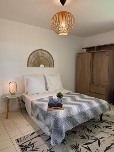 a bedroom with a bed with a tray with a hat on it at Cozy cocoon in La Madeleine in Cayenne