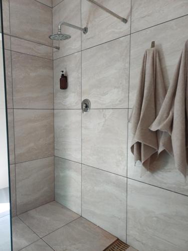 a shower stall with a glass door with towels at 7th Heaven Guest Unit in Paarl