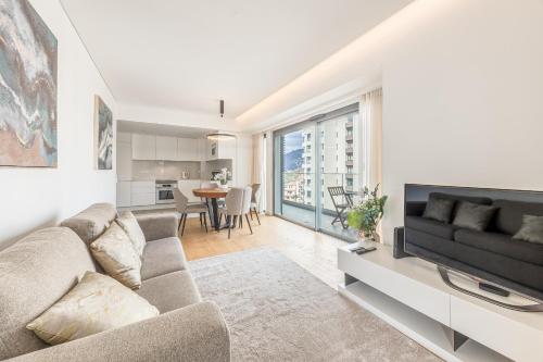 a living room with a couch and a tv at Acqua Residence in Funchal