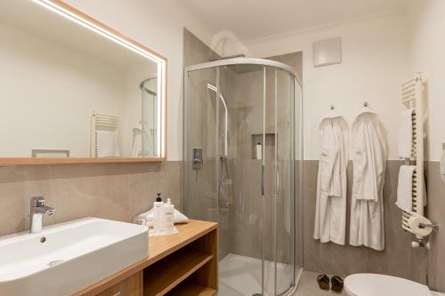 a bathroom with a sink and a shower at Hotel Sittnerhof in Merano