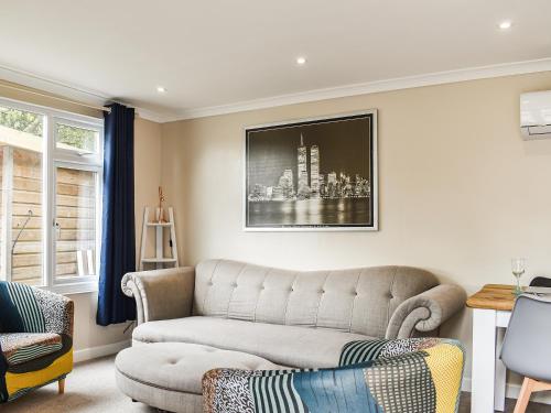 a living room with a couch and a chair at The Stables in Edmondsham