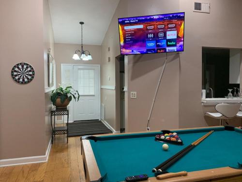 a living room with a pool table and a tv at Ortona's Best Kept Secret Three-Two Spacious Home in Orlando