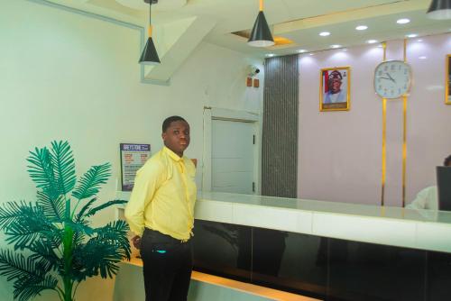 a man standing in front of a reception desk at Greystone Hotel in Asaba