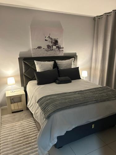 a bedroom with a large bed with a picture of a cow at 51 Lazarett Loft & Car Rental in Windhoek