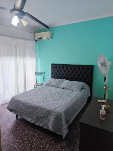 a bedroom with a bed and a blue wall at Dpto de Licia in Cipolletti