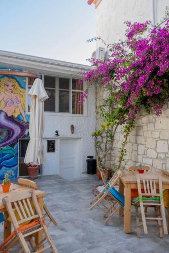 a patio with chairs and a table and flowers at Das Hotel Alacati in Alaçatı
