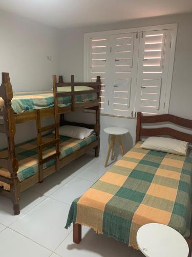 a bedroom with two bunk beds and a table at Apartamento térreo no Morro Branco Marina II in Beberibe