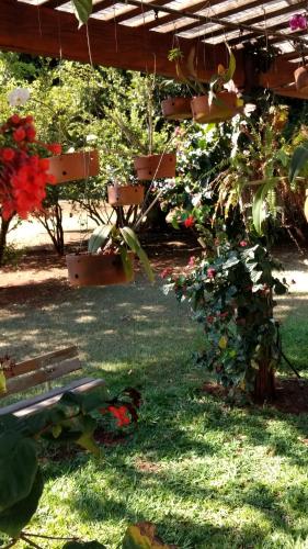 a garden with a bench in the grass with flowers at Hotel Recreio São Jorge in Jaboticabal