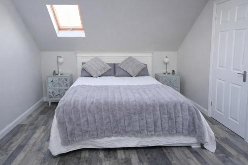 a white bedroom with a large bed and a skylight at Lisburn - 1 Bedroom - sleeps 2 - Street parking in Lisburn