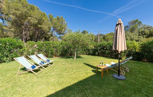 two lawn chairs and an umbrella and a table with a table at Amedart in Alcudia