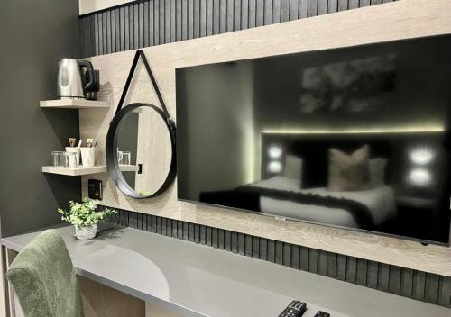 a bathroom with a mirror and a sink with a bed at The Cycad Lodge & Chalets in Nelspruit