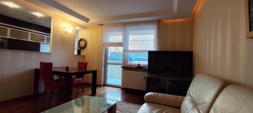 a living room with a couch and a dining room table at Apartament Rycerska LUX in Łomża
