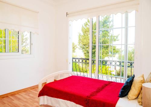 a white bedroom with a red bed and a window at Villa Cyprium in Kyrenia