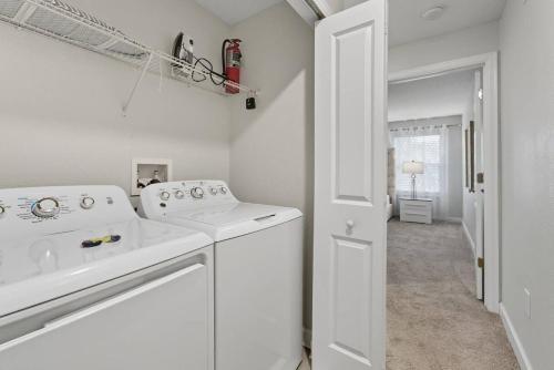 a white laundry room with a washer and dryer at Storey Lake 4BR w/ Private Pool near Disney in Kissimmee