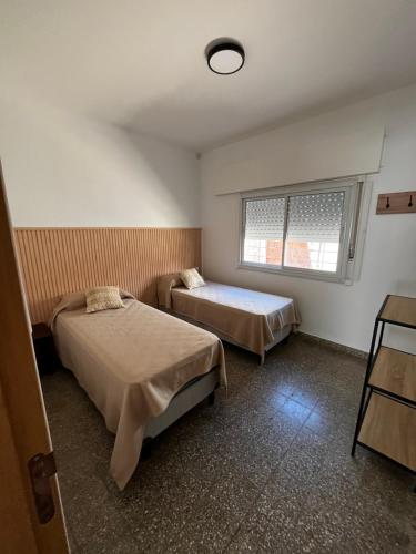 a room with two beds and a window in it at Departamentos Valquiria in Monte Hermoso