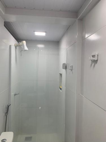 a bathroom with a shower with a glass door at Apartamento térreo no Morro Branco Marina II in Beberibe
