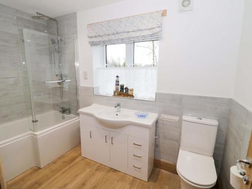 a bathroom with a toilet and a sink and a shower at The Barn in Redditch