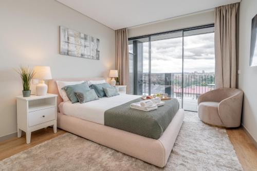 a bedroom with a bed and a chair and a window at Modern Porto Retreat by HostWise in Vila Nova de Gaia