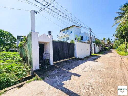 an empty street next to a white house at Second Home Resort- Homestay AC Room with Attached Bathroom and WiFi in Boralesgamuwa
