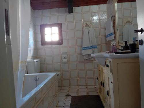 a bathroom with a tub and a sink and a bath tub at Ektor Villa in Agios Georgios