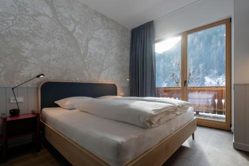 a bedroom with a bed with a large window at Ferienpension Senfter in Innervillgraten