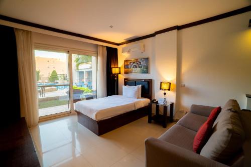 a hotel room with a bed and a couch at Panacea Suites Hotel in Borg El Arab