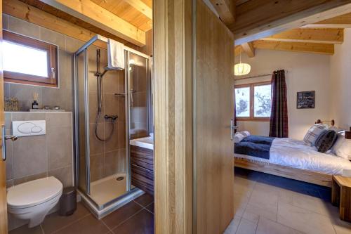 a bathroom with a bed and a shower and a toilet at Chalet Renard Roux in La Tzoumaz