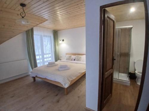 a bedroom with a bed and a large window at Hanul Ibăștean in Brădeţelu