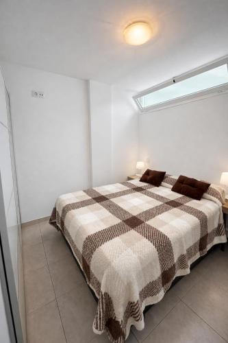 a bedroom with a bed with a checkered blanket at Apartamento Luxury in Maspalomas