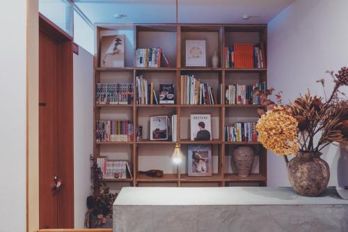 a book shelf filled with books in a room at women only nini hostel 伏見稲荷 in Kyoto