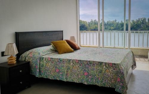 a bedroom with a bed and a large window at blu River villa Ambalangoda in Nikawatawana