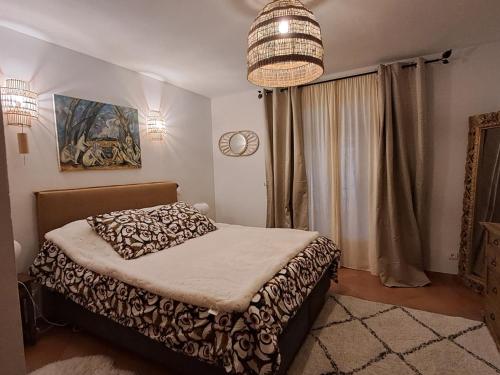 villa provençale في آرل: غرفة نوم بها سرير وثريا
