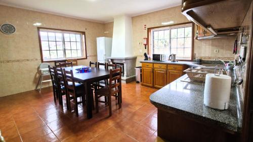 a kitchen with a table and some chairs in it at Martins House in Vila Viçosa