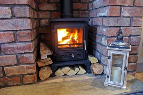 a brick fireplace with a stove and a lantern at No 1 Chapel Row in Bakewell