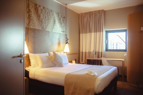 a hotel room with a bed and a window at Atlantis Alger Aéroport ex Ibis in Alger