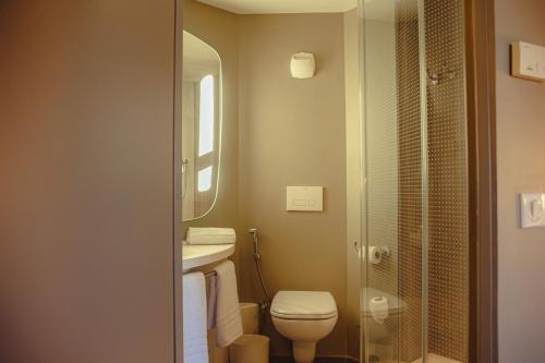 a bathroom with a toilet and a sink and a shower at Atlantis Alger Aéroport ex Ibis in Alger