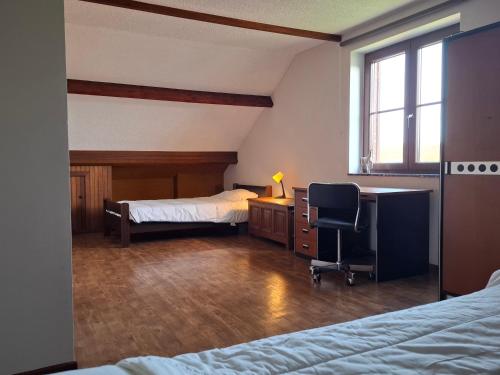 a bedroom with two beds and a desk and a chair at L'Echappée Belle in Beauraing