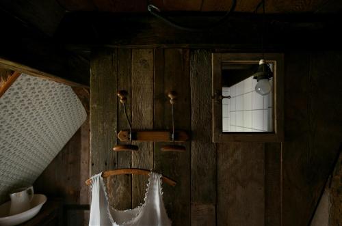 a bathroom with a wooden wall with a sink and a mirror at Chez Oma, La petite ferme in Weinbourg