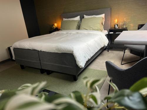 a bedroom with a bed with white sheets and pillows at Ikigai B&B in Oud-Turnhout