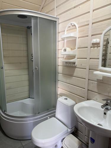 a bathroom with a shower and a toilet and a sink at Hotels mim in Vorokhta